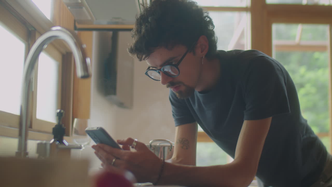 Man Using Smartphone while Cooking in Kitchen