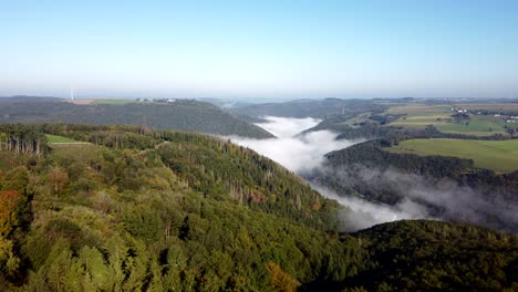 early autumn morning flight over the countryside of luxembourg, while the valleys are still filled with fog