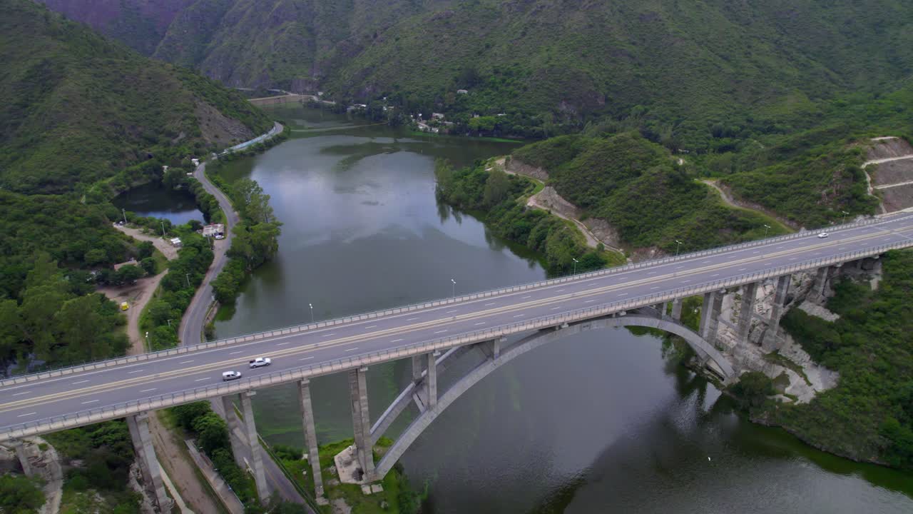 Aerial view of new highway bridge over San Roque lake with cars moving on road. Argentina