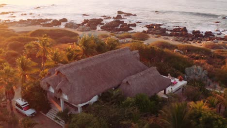 sale el sol mientras el dron gira alrededor de hermosas villas de alquiler de lujo frente al mar en oaxaca méxico