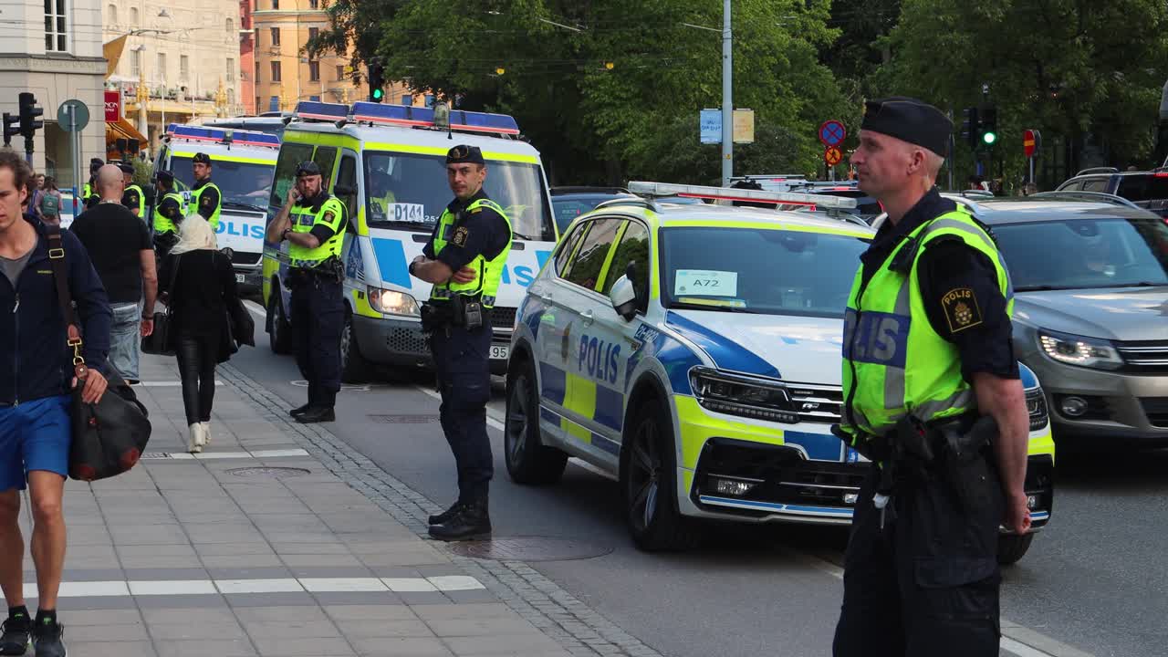 Police Officers Stand Guard On Duty At Protest Rally In Stockholm, Sweden. Static Shot