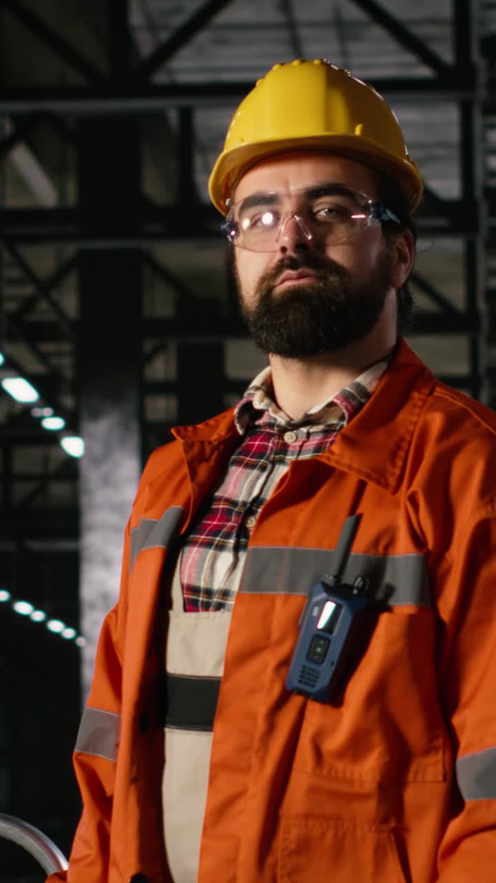 Video verticale. Ritratto di personale con casco e occhiali di sicurezza che esamina il design industriale