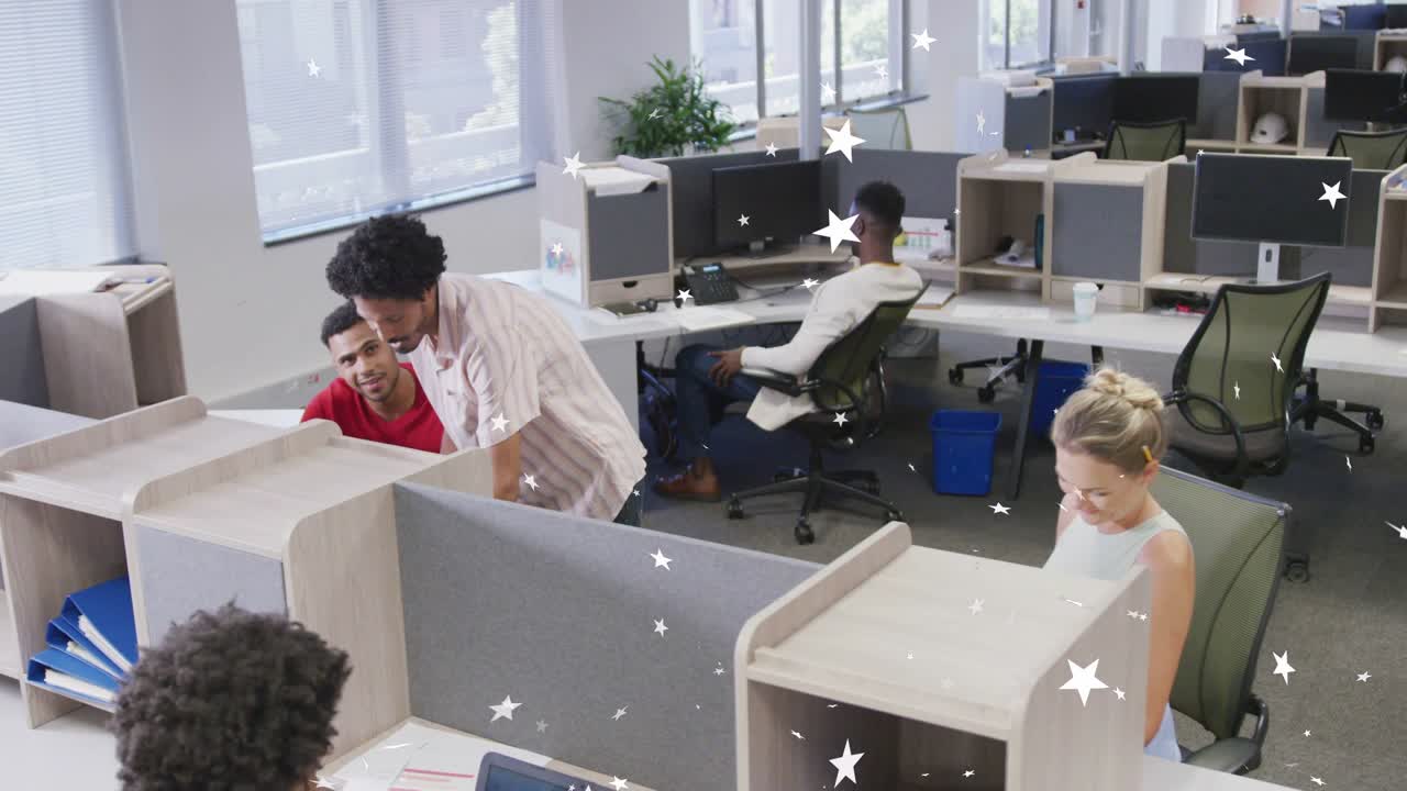 Pria berdiri menunjuk pekerja yang duduk, meninjau layar di kantor, dengan overlay bintang di seluruh monitor.