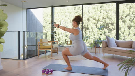 practicing yoga, plus size woman stretching on mat in modern living room