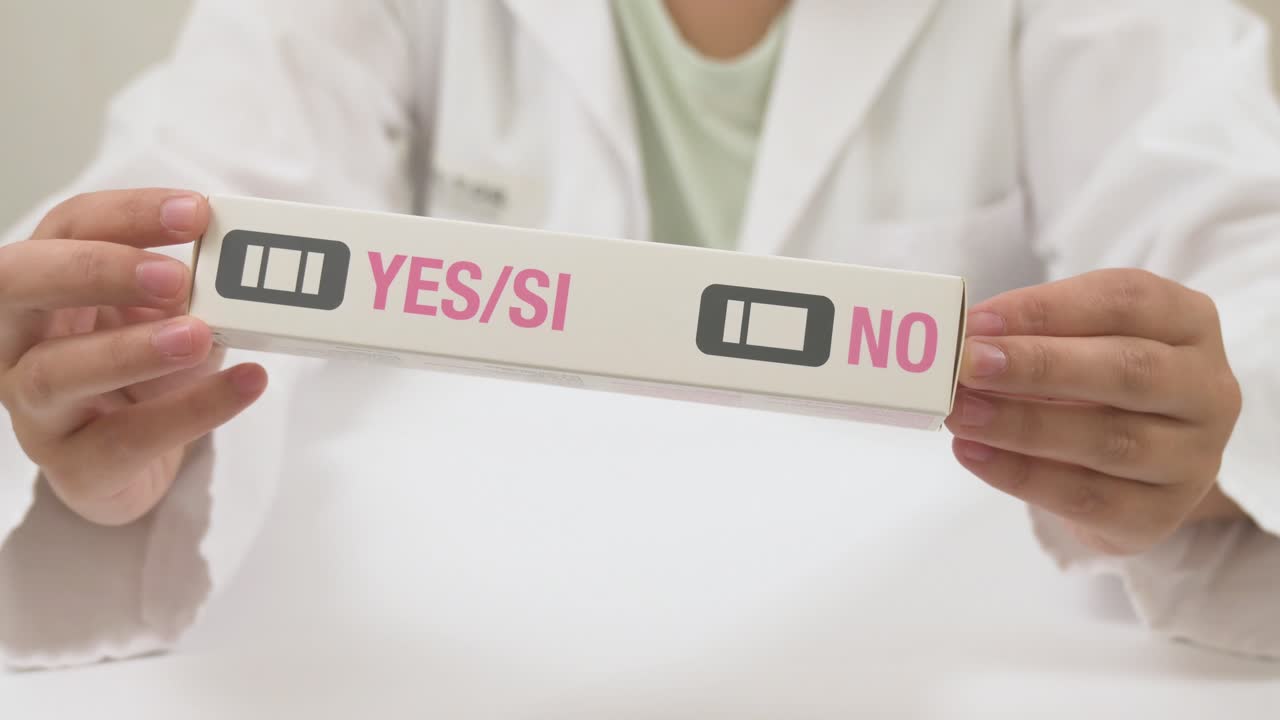 Female doctor in a white coat holding a positive pregnancy test kit in a medical office