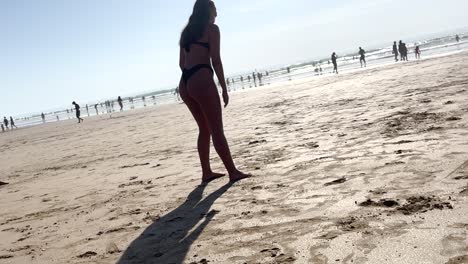 Joyful-girl-having-fun-on-the-beach-under-the-European-sun,-enjoying-a-sunny-day-by-the-shore