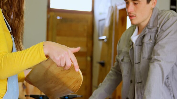 Side view of young woman discussing over skateboard deck with young caucasian customer at shop 4k