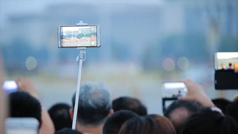스마트폰으로 인파를 지켜보는 행사