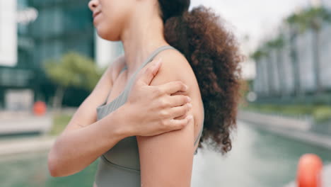 woman experiencing shoulder pain while exercising outdoors