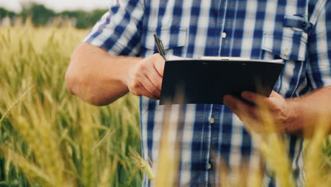 el agricultor firma el documento y le da la mano a un compañero en el fondo de un campo de trigo