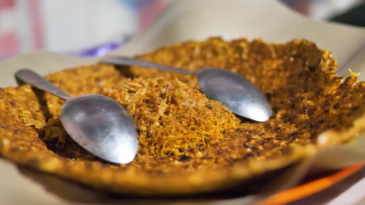 Slow motion shot of a traditional Indonesian snack Kerak Telor served on a plate