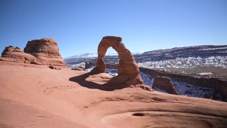 arco delicado con montañas de la sal cubiertas de nieve en el fondo, estático