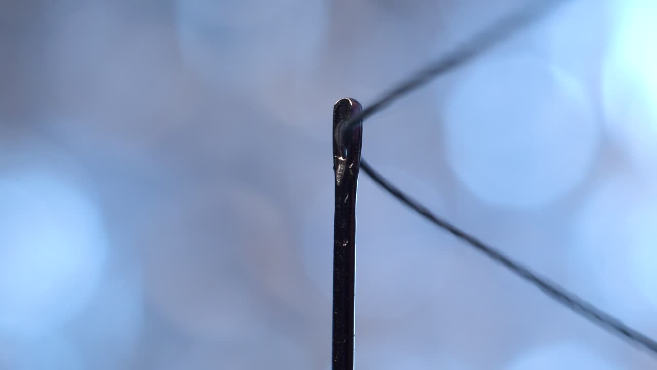 экстремальное макросъемка вдевания нитки в иголку с идеальной точностью