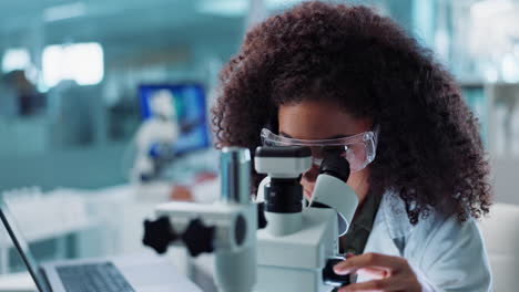 young woman scientist using microscope in a laboratory