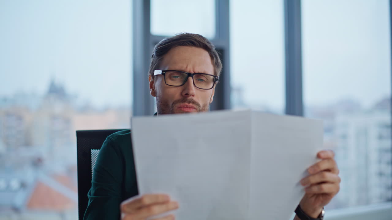 Financial analyst reading documents at office workplace by window closeup