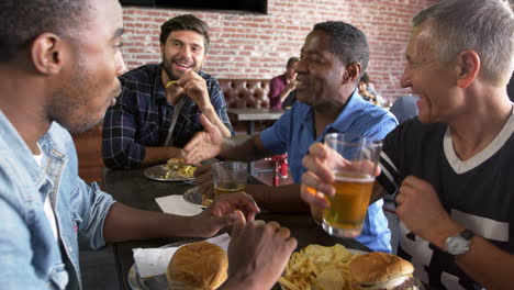 grupo de amigos masculinos comiendo en un bar deportivo filmado en r3d