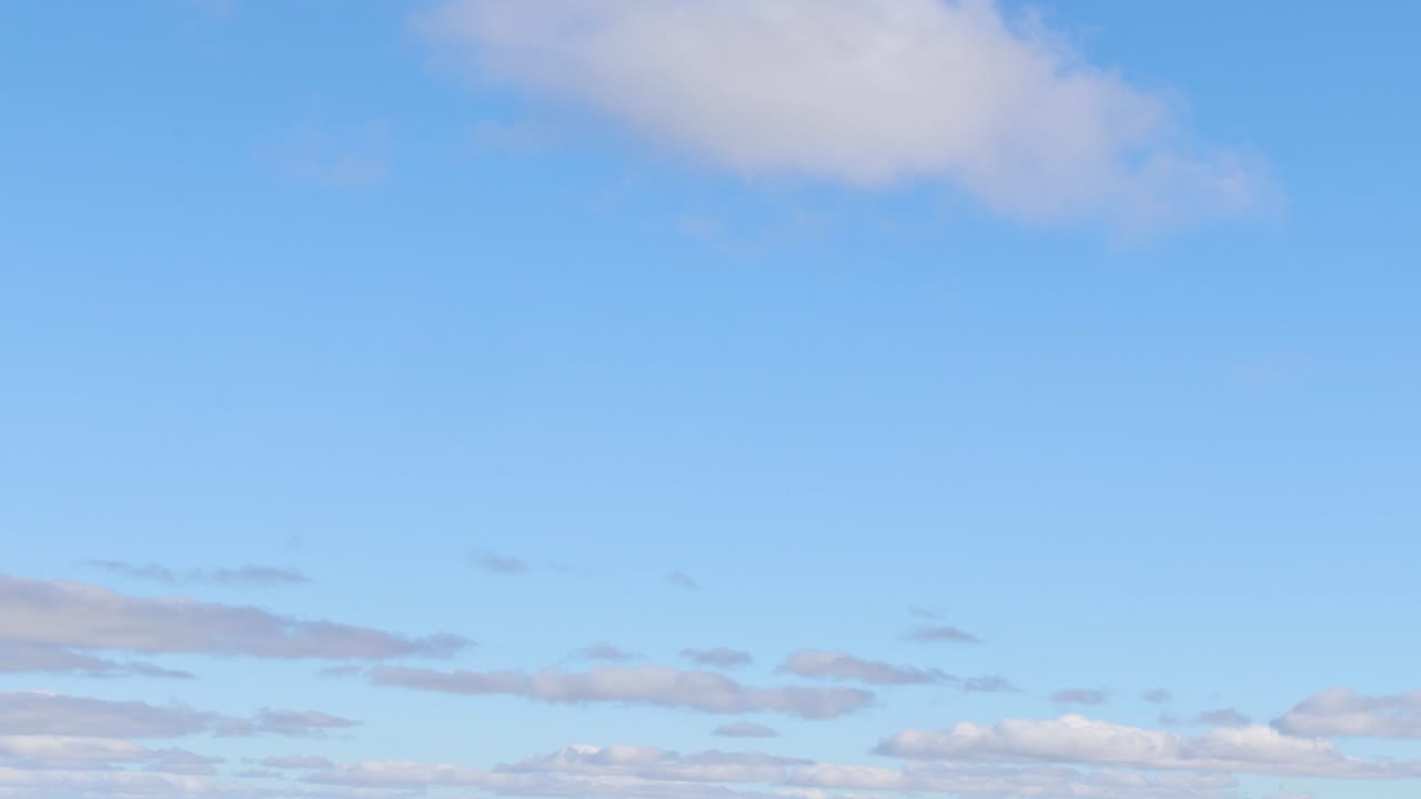 Clouds drift gently in a clear sky