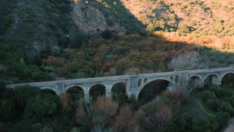 aerial rotates with cyclists crossing old rail trail trestle bridge