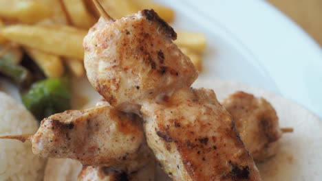 chicken skewers with fries and rice