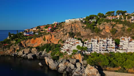 Exotic-hotel-on-rocky-cliff-side-near-ocean-in-Spain,-aerial-view