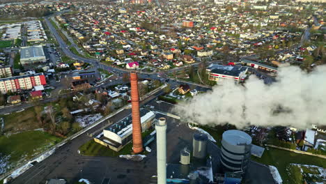 Chimenea-Que-Arroja-Vapor,-Humo-Y-Contaminación-En-Una-Ciudad---órbita-Aérea