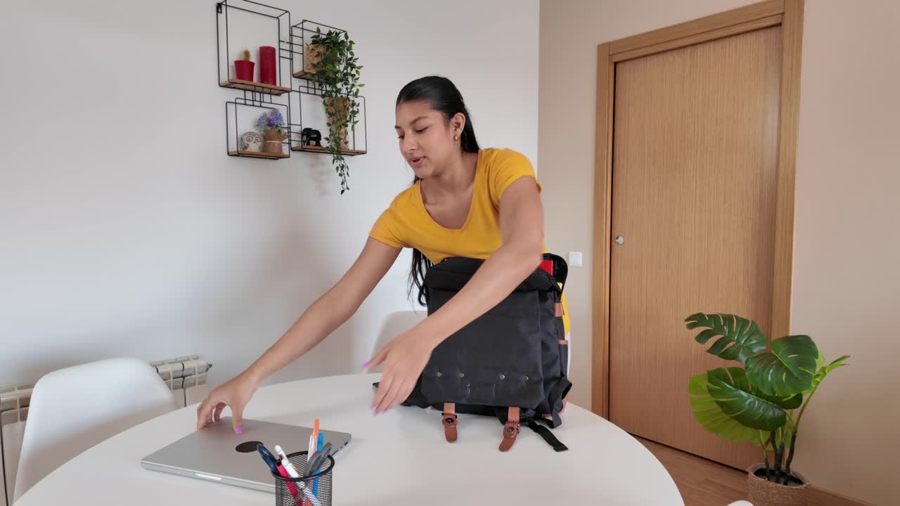 Woman packing a backpack at home
