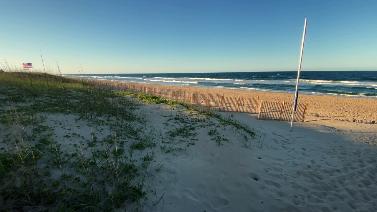 Hari cerah yang indah di pantai tenang dan murni dengan langit biru di North Carolina, di Outer Banks, Nags Head selama awal musim panas.