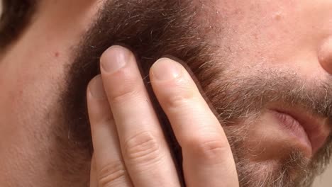face shave: razor cutting beard stubble - close up view detail