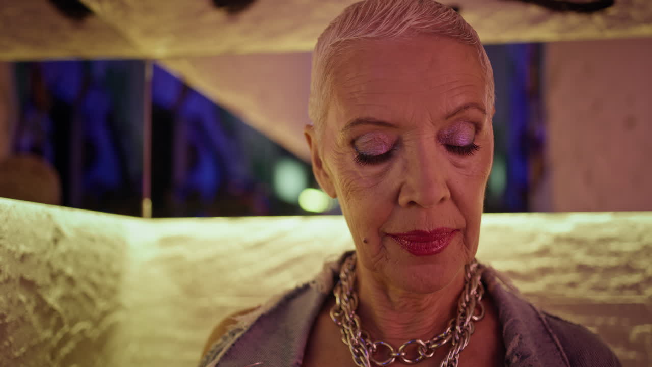 Mature woman posing cafe in modern outfit closeup. Trendy senior on bar date