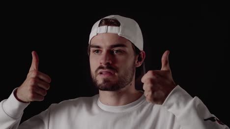 trendy 20s man giving both thumbs up, appreciative gesture, close, black background