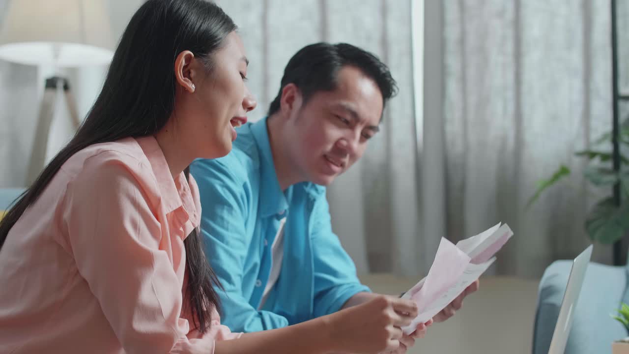 Close Up Of Asian Couple With A Laptop Arguing About The Bill Then Having Headache Due To Financial Problem