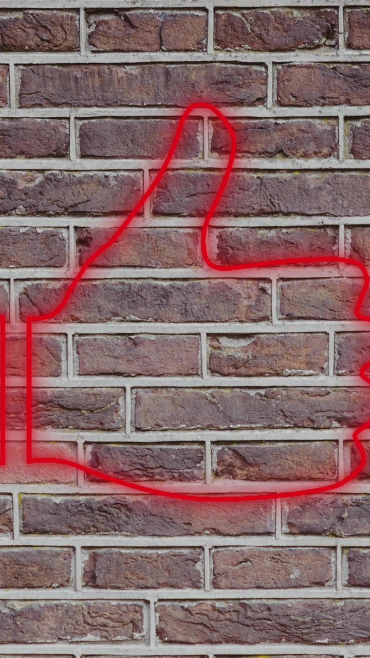 Insegna al neon a forma di cuore su muro di mattoni 4k