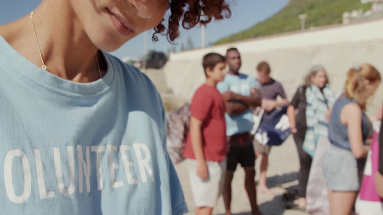 해변 4k에서 클립보드에 글을 쓰는 여성 자원봉사자