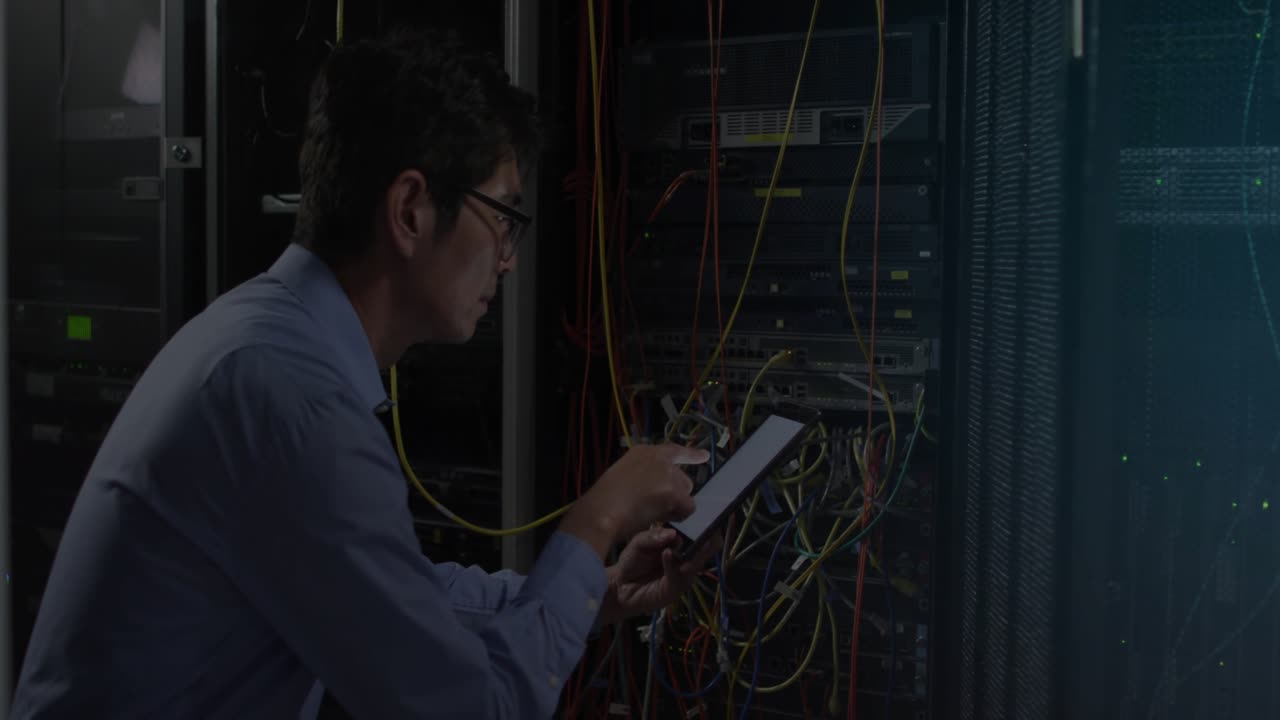Tech crouching at server rack, tapping tablet and adjusting color cables, initiating CLOUD forming