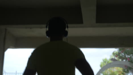 Un-Joven-Con-Auriculares-Recorre-El-Callejón-De-La-Ciudad-De-Perea,-Grecia