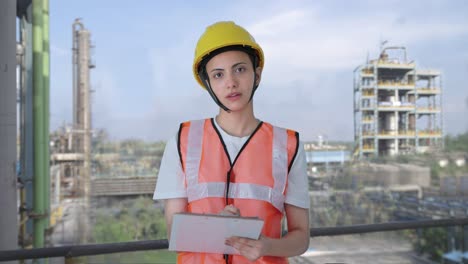 indian female construction worker taking notes of building