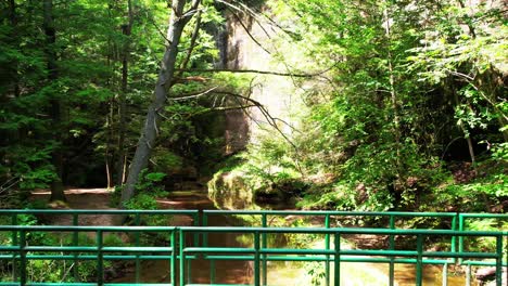 un dron disparó sobre un pequeño arroyo y reveló un pequeño puente peatonal en el parque estatal hocking hills oh