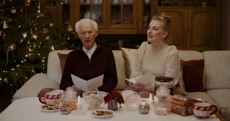 grandfather and granddaughter caroling at home