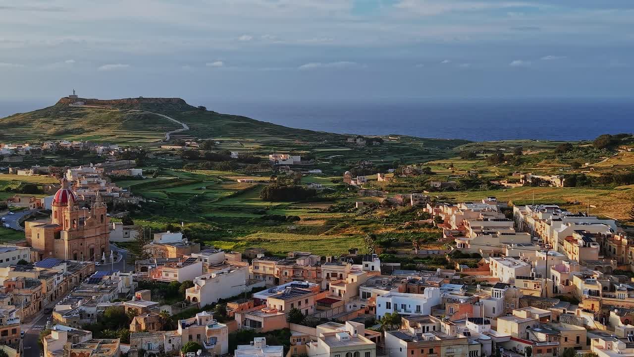 Vista di una città costiera e di un paesaggio a Malta durante il tramonto