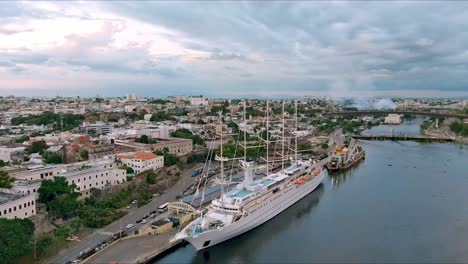 msy wind surf ship anchored in colonial zone port at sunset with cityscape