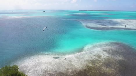 aerial view tracking man kiteboard flying in national park los roques