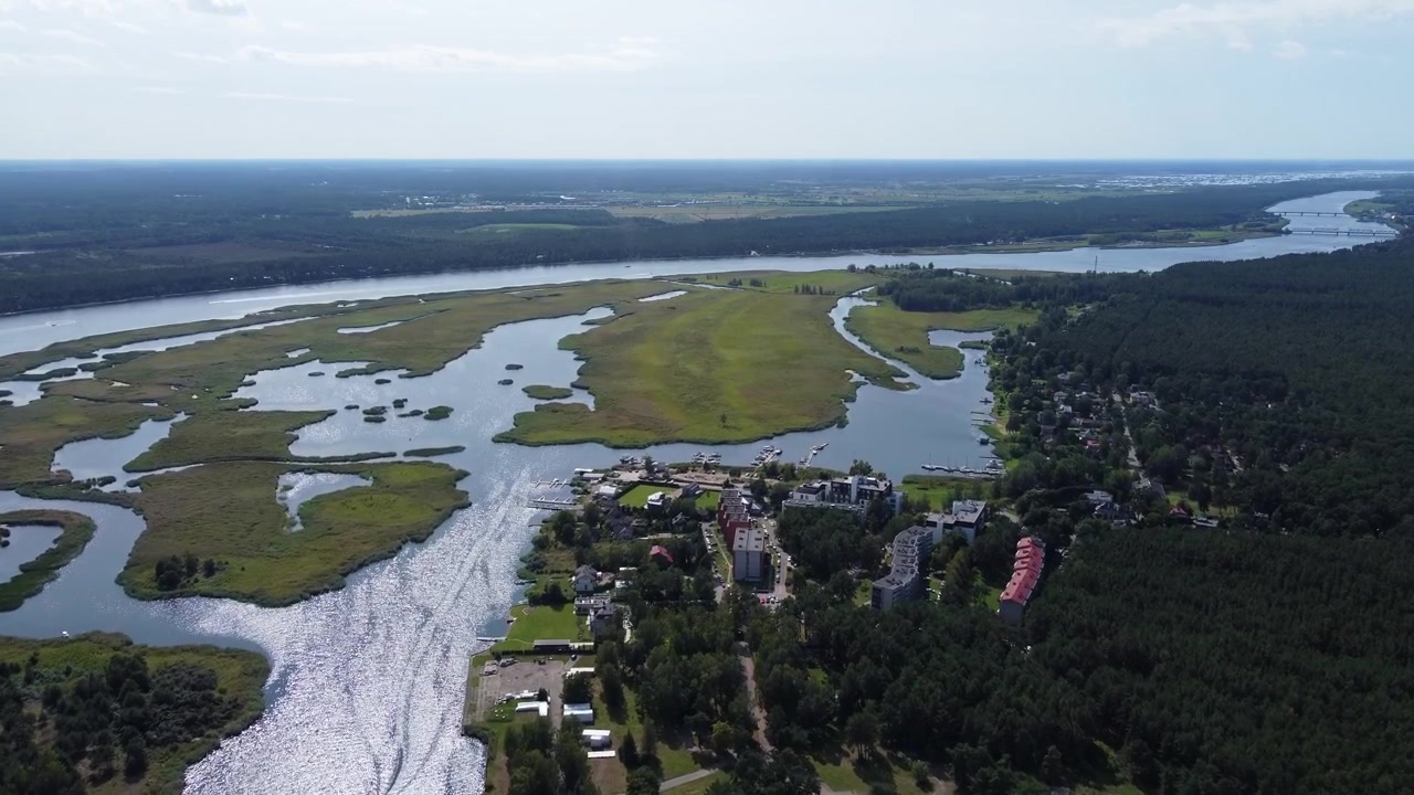 Bellissimo fiume e palude vicino a una piccola cittadina in Lettonia, vista aerea con drone