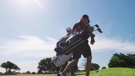 caucasian male golfers standing on a golf course on a sunny day