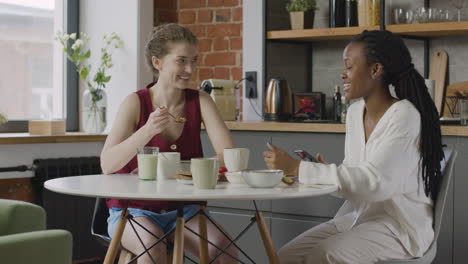 dos compañeras de cuarto desayunando y hablando juntas en casa 1