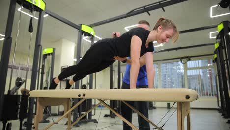 woman performing a plank exercise with personal trainer supervision