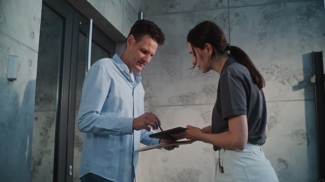 Man receives and signs for a package from a delivery woman