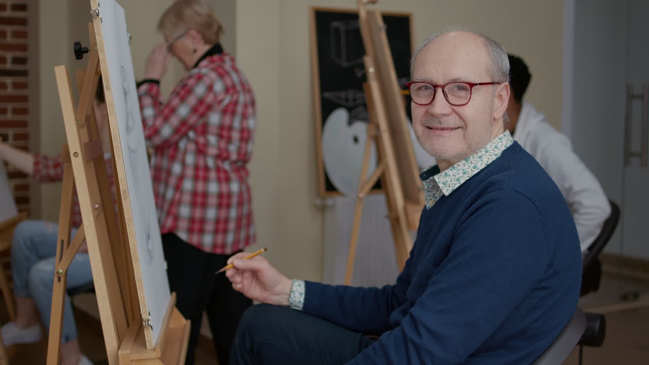 Portrait of senior man enjoying art class to develop drawing skills