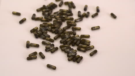 brown cannabis oil capsule pills are poured from small glass bottle