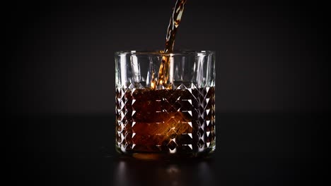 cola being poured into a glass with ice