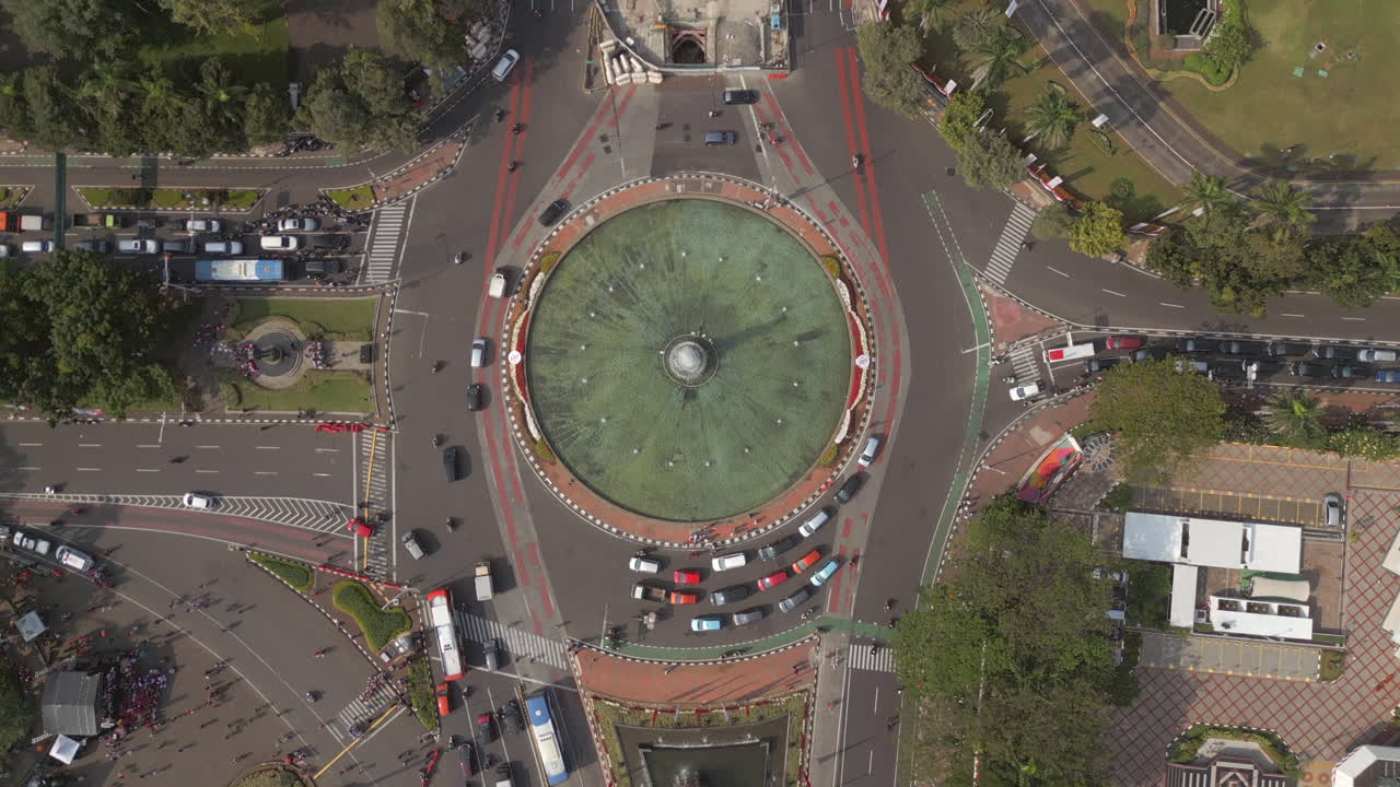 Traffic Passing Thamrin Fountain North To South In Jakarta Indonesia Drone High Shot 4K 60FPS